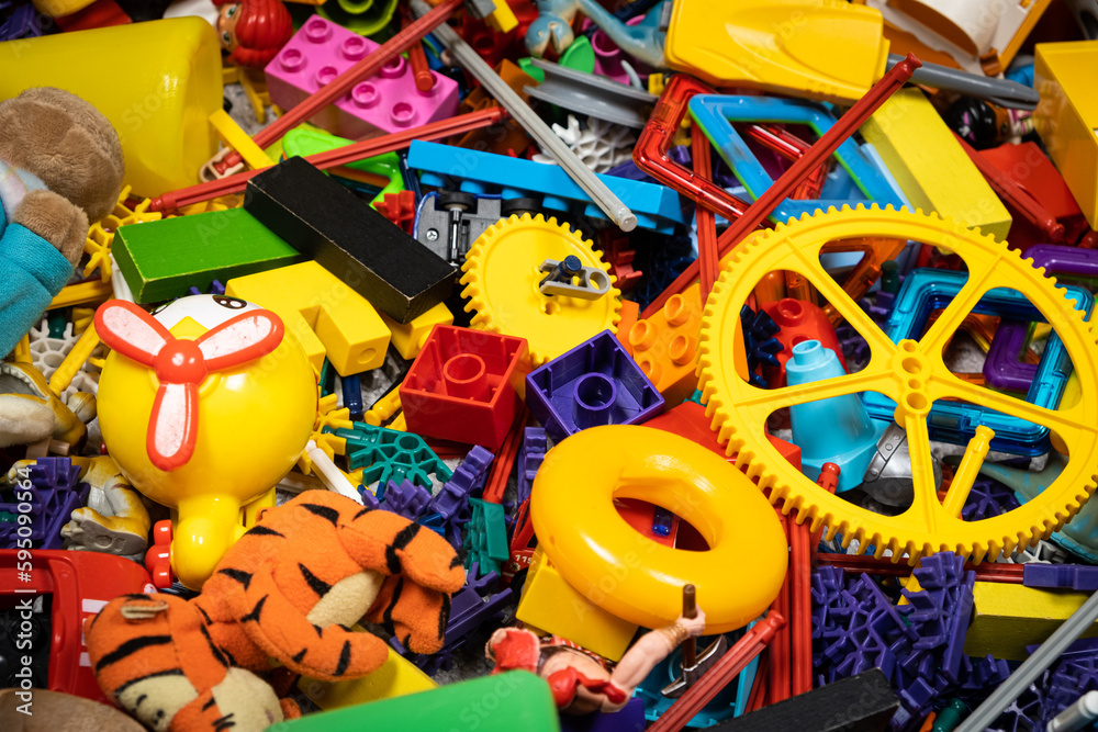 Fototapeta premium An abundance of toys in the children's room, a lot of plastic multi-colored parts from designers, spare parts for toys, figurines and cubes.