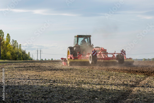 tractor during sowing in an open field on a sunny day