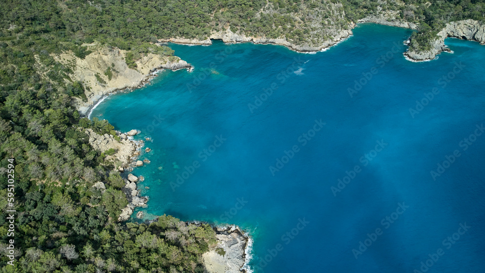 A breathtaking aerial view of a peaceful turquoise sea, lush greenery and crystal blue water at the beach. Turkish mediterranean coast.