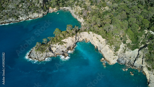 A breathtaking aerial view of a peaceful turquoise sea, lush greenery and crystal blue water at the beach. Turkish mediterranean coast. © Érik Glez.