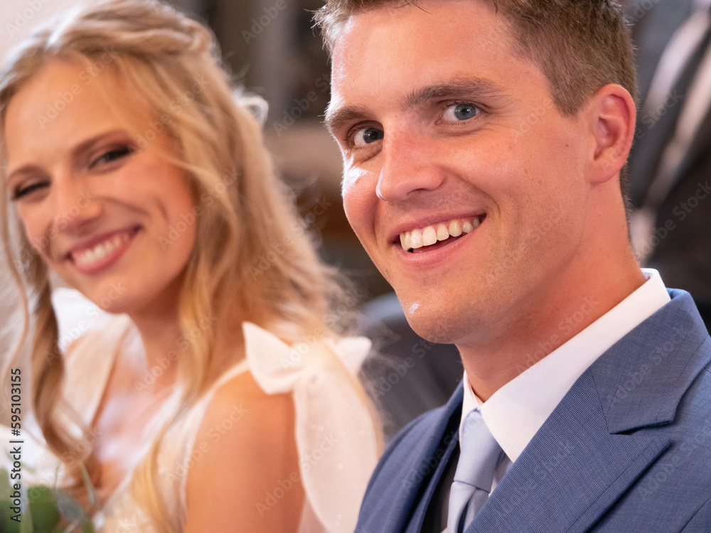 PORTRAIT, DOF: Smiling groom and bride at traditional wedding mass in church PORTRAIT, DOF: Smiling groom and bride at traditional wedding mass in church