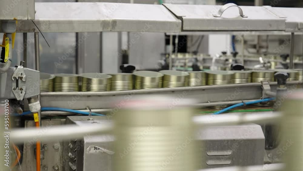 Sealed food cans on a conveyor belt in a food production facility
