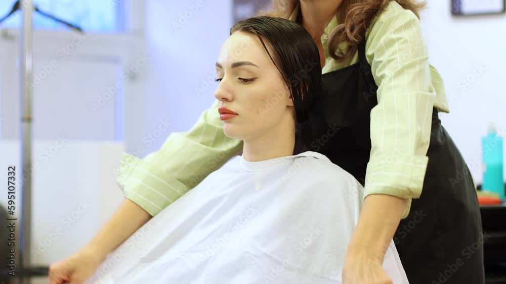 hairdresser putting a white cap on a beautiful girl.in a beauty salon hairdresser putting a white cap on a beautiful girl.in a beauty salon