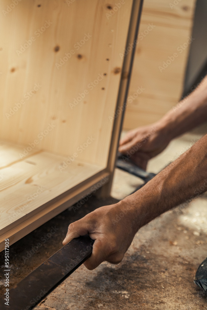 Carpenter's muscular hand holding metal tool Carpenter's muscular hand holding metal tool