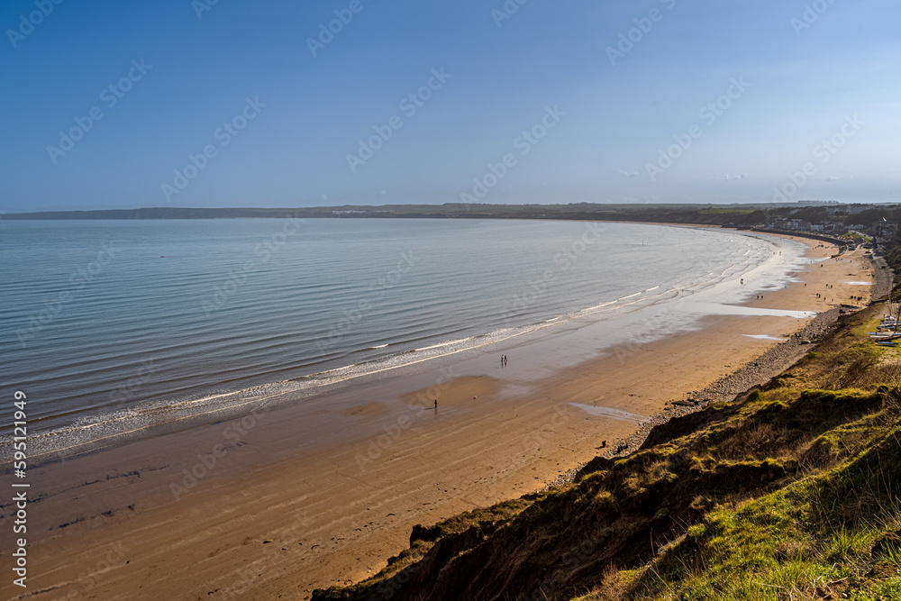 People walking on the beach in the afternoon People walking on the beach in the afternoon