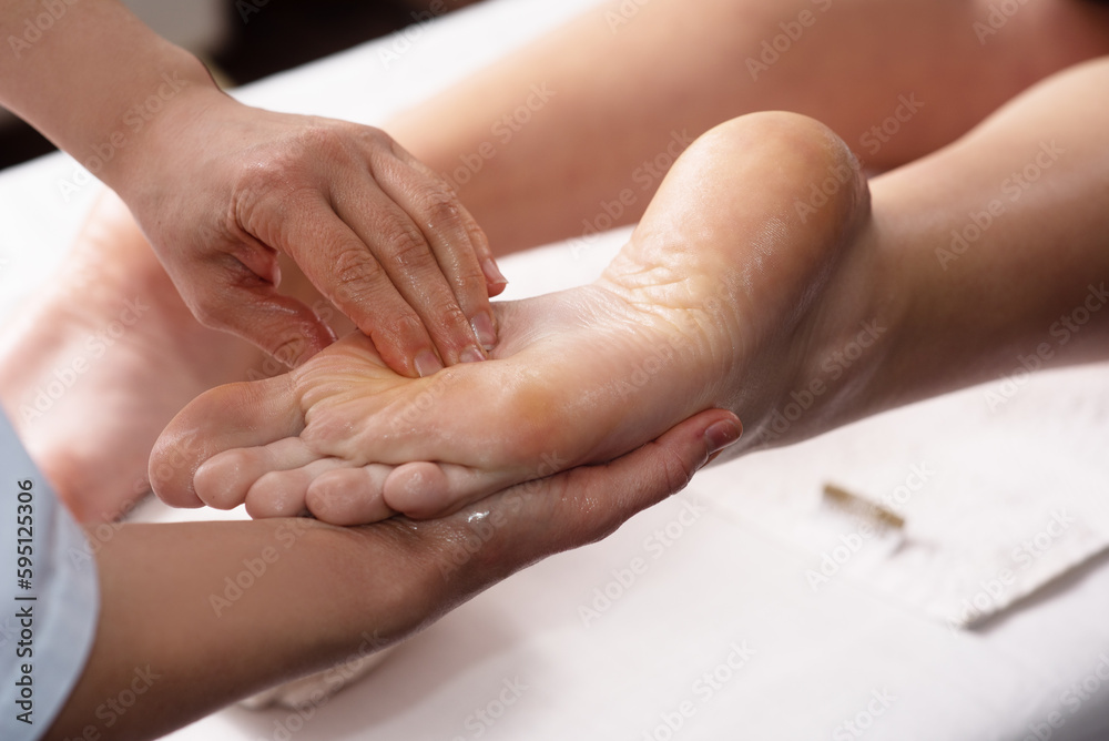 Masseur doing foot massage with oil in spa salon. Spa procedures. Body care concept. Close-up view Masseur doing foot massage with oil in spa salon. Spa procedures. Body care concept. Close-up view