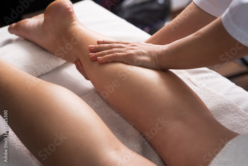 Masseur doing foot massage with oil in spa salon. Spa procedures. Body care concept. Close-up view