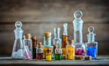 Vintage medications in small bottles on wood desk. Old medical, chemistry and pharmacy history concept background. Retro style.
