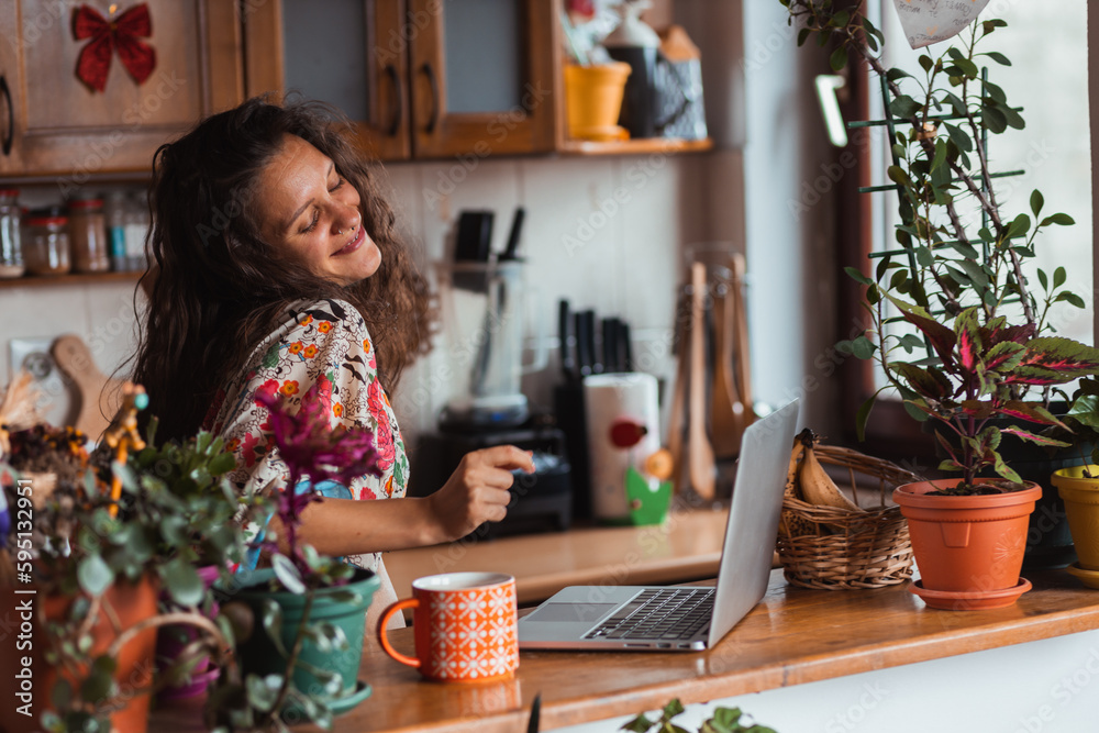 Young hippie woman with curly hair dancing around in her kitchen. Young hippie woman with curly hair dancing around in her kitchen.