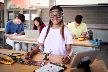 Looking at camera portrait of a young student wearing safety goggles in technical vocational training college, the lesson in High School. Education and technology concept. High quality photo