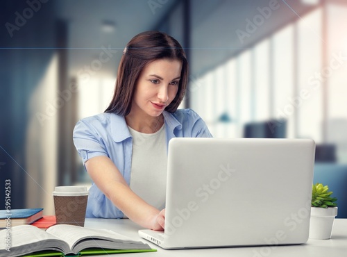 Beautiful young woman working on laptop in office