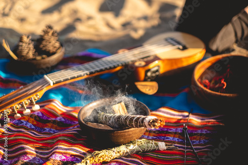 Mystical andean journey: peruvian blanket, charango, crystals and burning holy wood incense in the desert sand