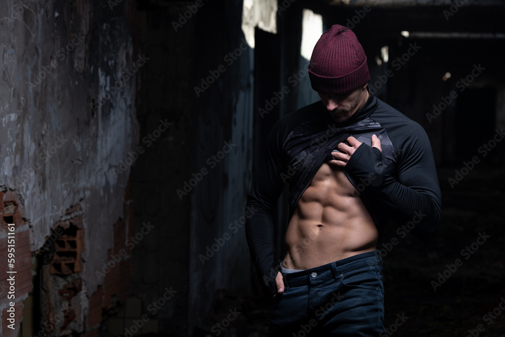 Man Flexing Abdominal Muscles in Ruins
