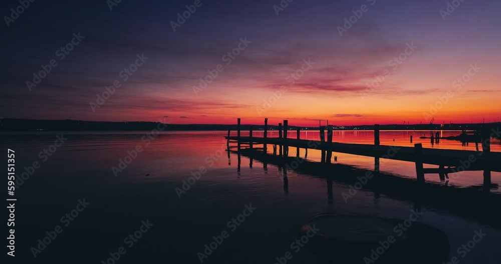 Sea lake sunset over old wooden jetty pier on shore,relaxing nature landscape Sea lake sunset over old wooden jetty pier on shore,relaxing nature landscape