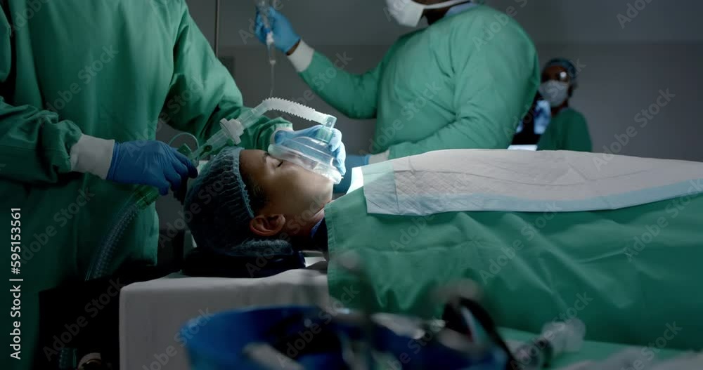 Diverse surgeons with face masks using oxygen mask on patient in operating room in slow motion