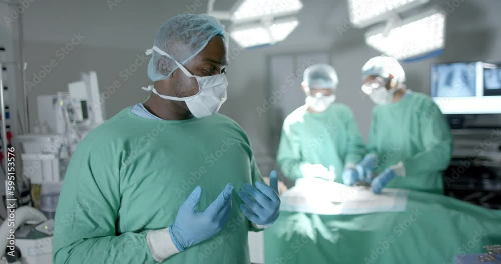 Portrait of diverse surgeons with face masks during surgery in operating room in slow motion Portrait of diverse surgeons with face masks during surgery in operating room in slow motion