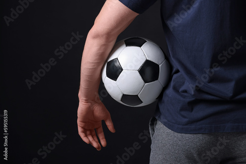 Athletic man with soccer ball on black background, closeup © New Africa
