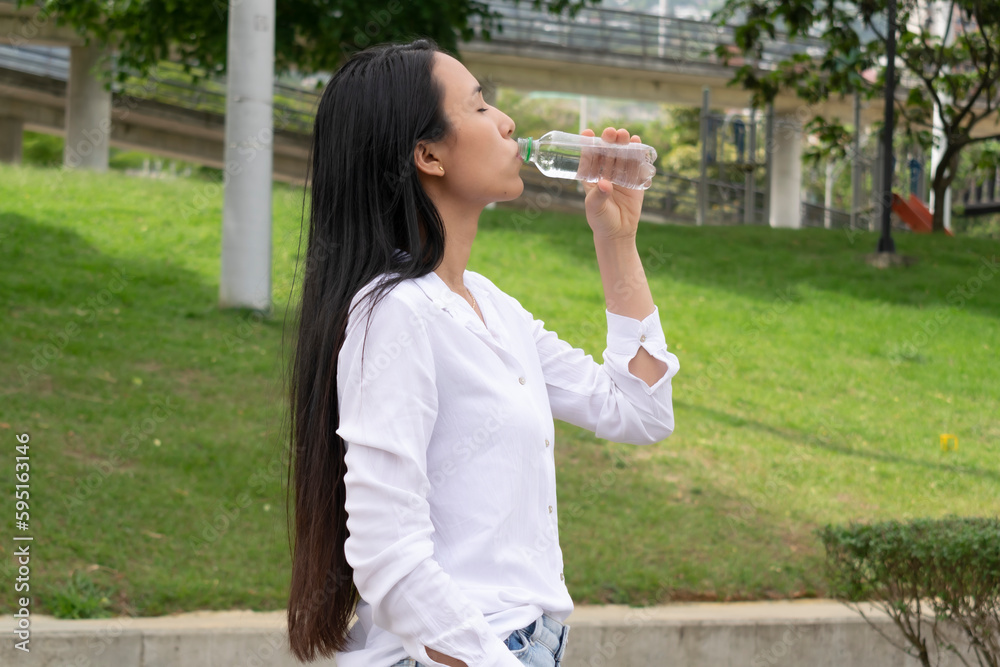 beautiful latin woman drinking water from bottle. beautiful latin woman drinking water from bottle.