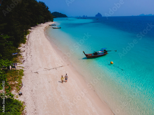a couple walking at the beach of Koh Kradan Island in Thailand photo