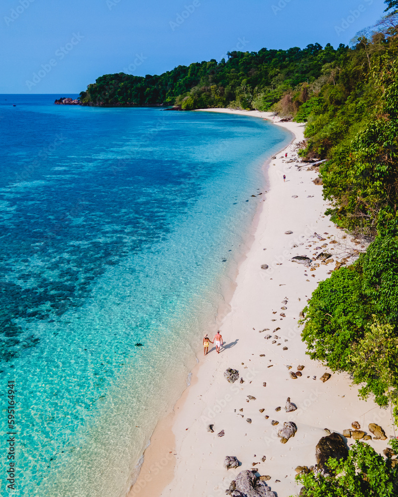 a couple walking at the beach of Koh Kradan Island in Thailand