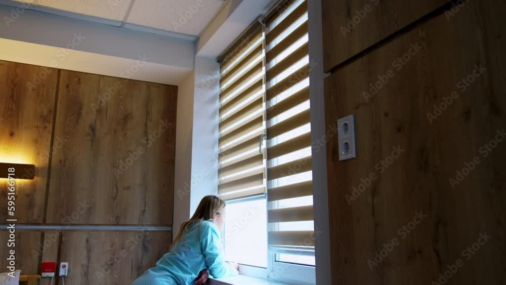 Caucasian woman stands leaned on the window-sill looking into window. Future mom in the maternity hospital ward. Caucasian woman stands leaned on the window-sill looking into window. Future mom in the maternity hospital ward.