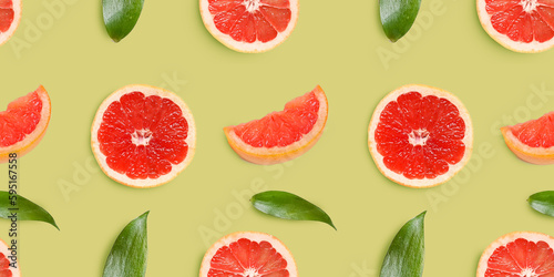 Composition with bottles of essential oil, plant leaves and grapefruit on yellow background