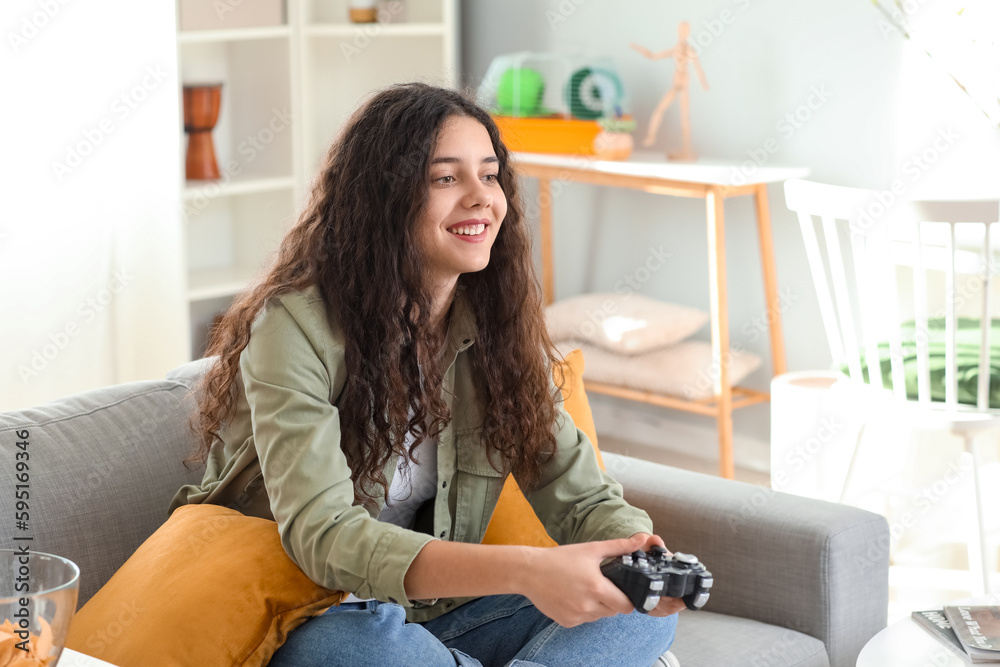 Obraz premium Teenage girl playing video game at home