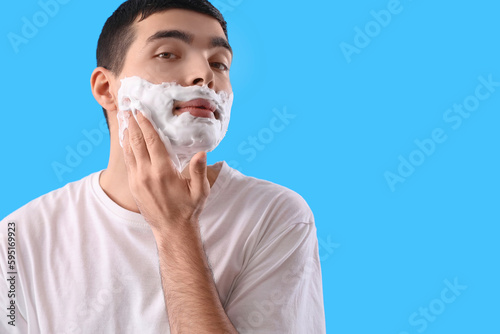 Young man with shaving foam...