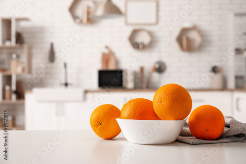 Bowl with oranges on table in interior of modern kitchen