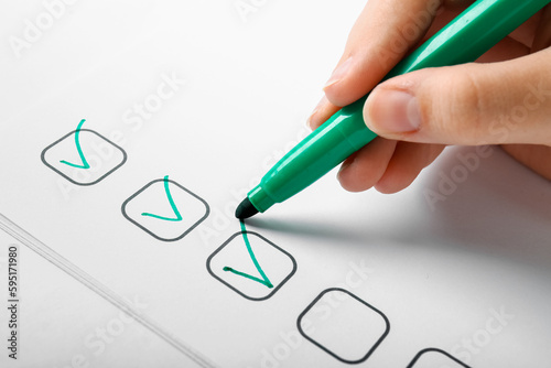 Woman marking on checklist ...