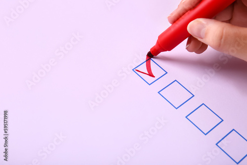 Woman marking on checklist ...