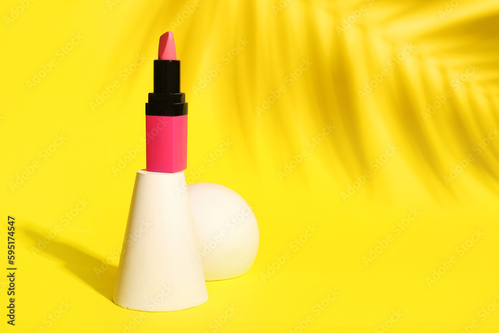 Plaster podiums with beautiful lipstick and palm leaf shadow on yellow background Plaster podiums with beautiful lipstick and palm leaf shadow on yellow background