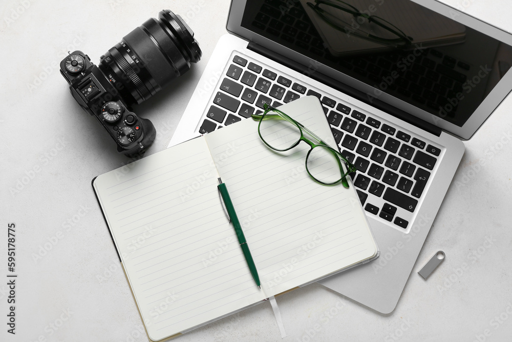 Notebook with eyeglasses, laptop and photo camera on white background - obrazy, fototapety, plakaty 