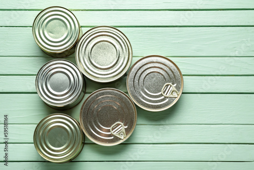 Fotografía Assortment of tin cans with fish on green wooden table