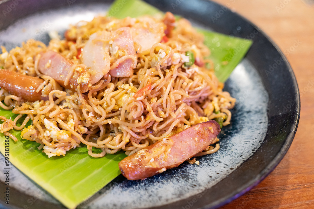 Mama drunken noodles. Noodles spicy in the bowl with ingredients on wooden background.
