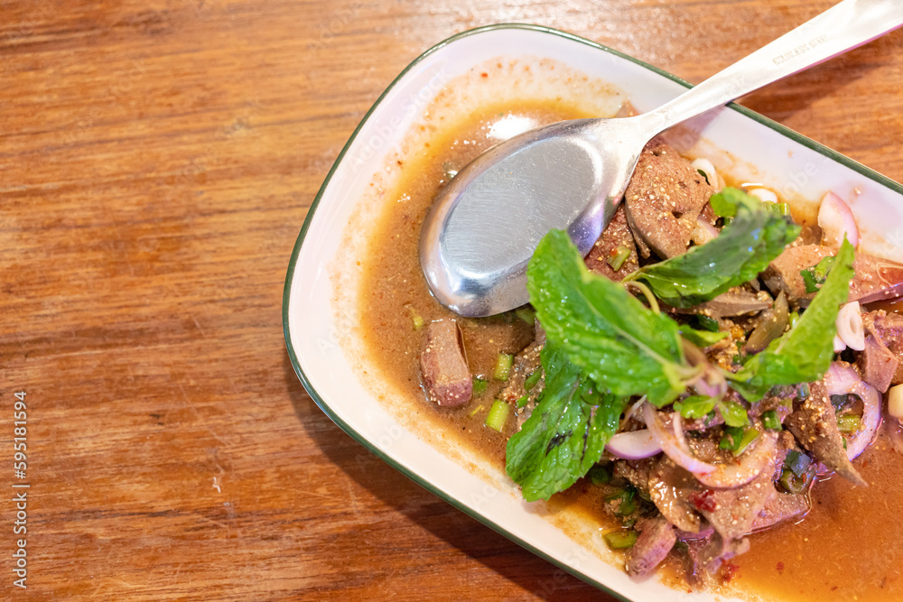 Sweet liver salad, Thai food. delicious spicy sweet liver on a wooden table background.