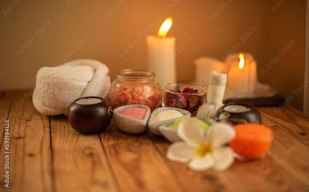 Placement of spa salt White frangipani flowers with soft glow in a spa setting, on a brown table. Placement of spa salt White frangipani flowers with soft glow in a spa setting, on a brown table.