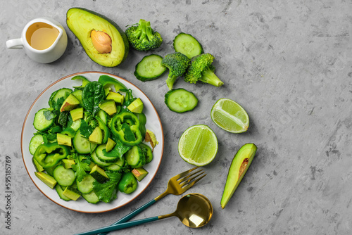 Plate of salad with green vegetables and ingredients on grey grunge background