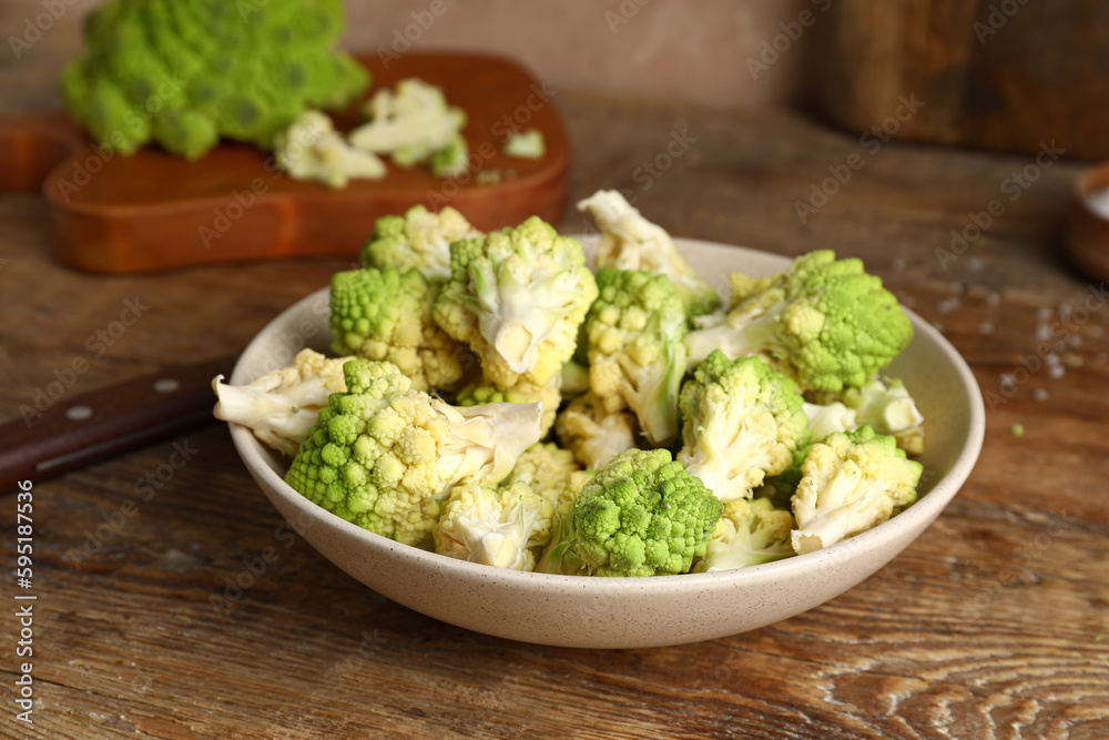 Bowl with baby romanesco cabbage on wooden table Bowl with baby romanesco cabbage on wooden table