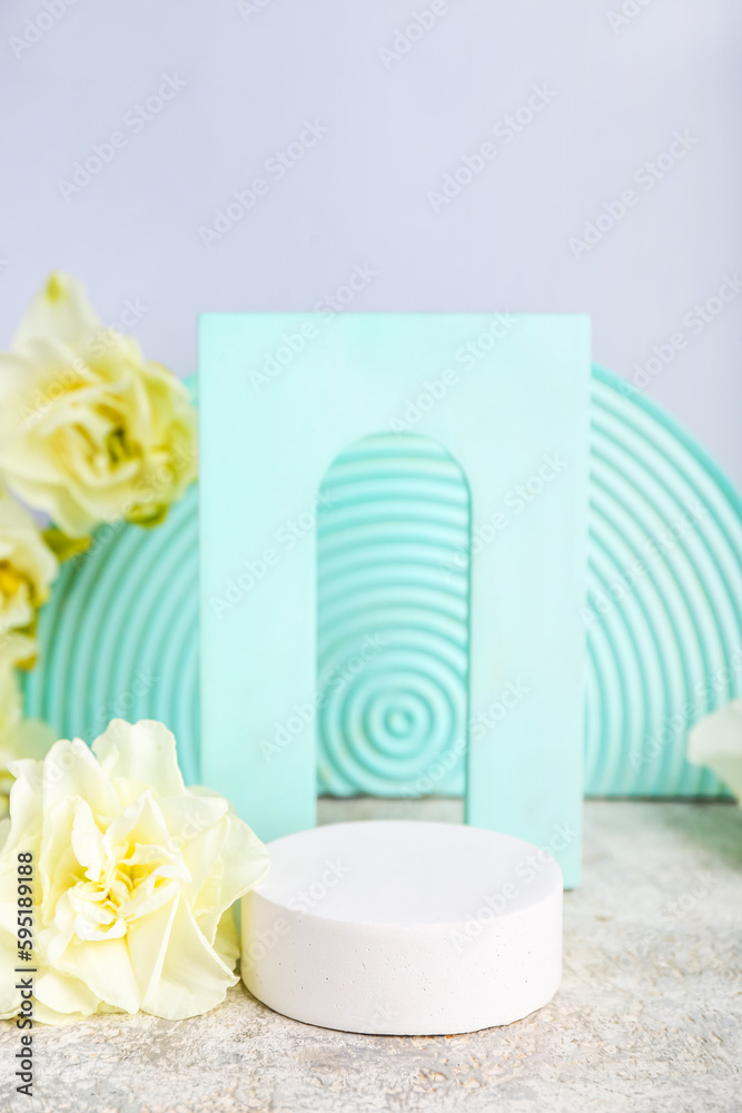 Decorative plaster podiums with flowers on grunge table against white background Decorative plaster podiums with flowers on grunge table against white background