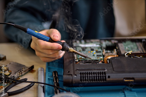 focus on unrecognizable engineer technician hands repairing faulty on laptop computer in electric device technology service, male using special tools. Maintenance notebook support service engineer