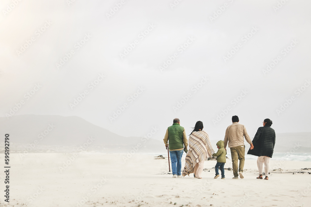 Children, holding hands and family walking at the beach in winter for quality time, love and care outdoor. Men, women or grandparents with parents and kids with mockup on a travel vacation in winter