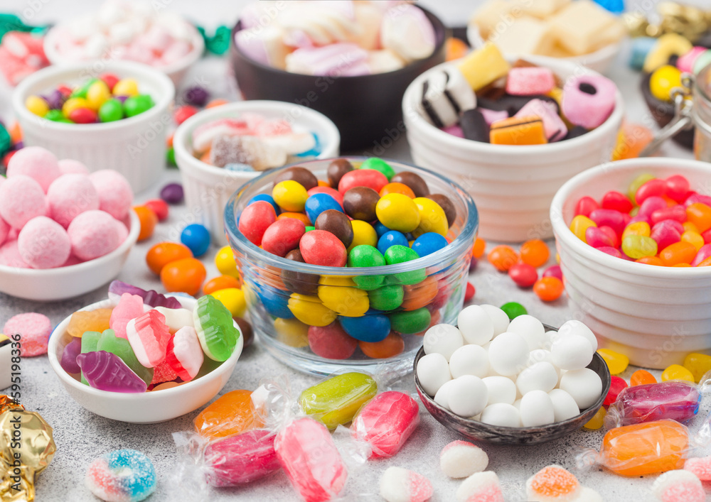 Milk chocolate candies woth shell in jar with various jelly gums candies on white background with liquorice allsorts and strawberry bonbons with different sour sugar gums. Milk chocolate candies woth shell in jar with various jelly gums candies on white background with liquorice allsorts and strawberry bonbons with different sour sugar gums.