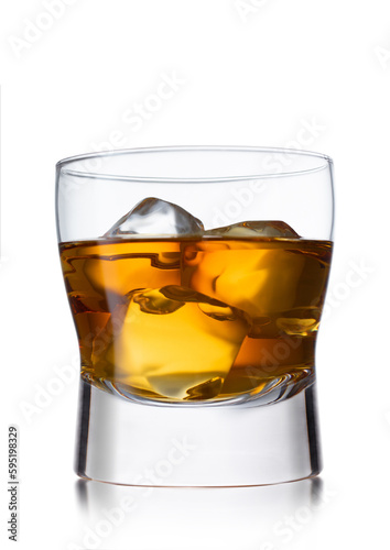 Large glass of whiskey with ice cubes on white background.