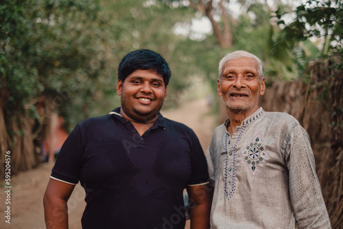South asian elderly grandfather smiling with his overweight grandson, family happiness concept, togetherness concept, fresh air environment 