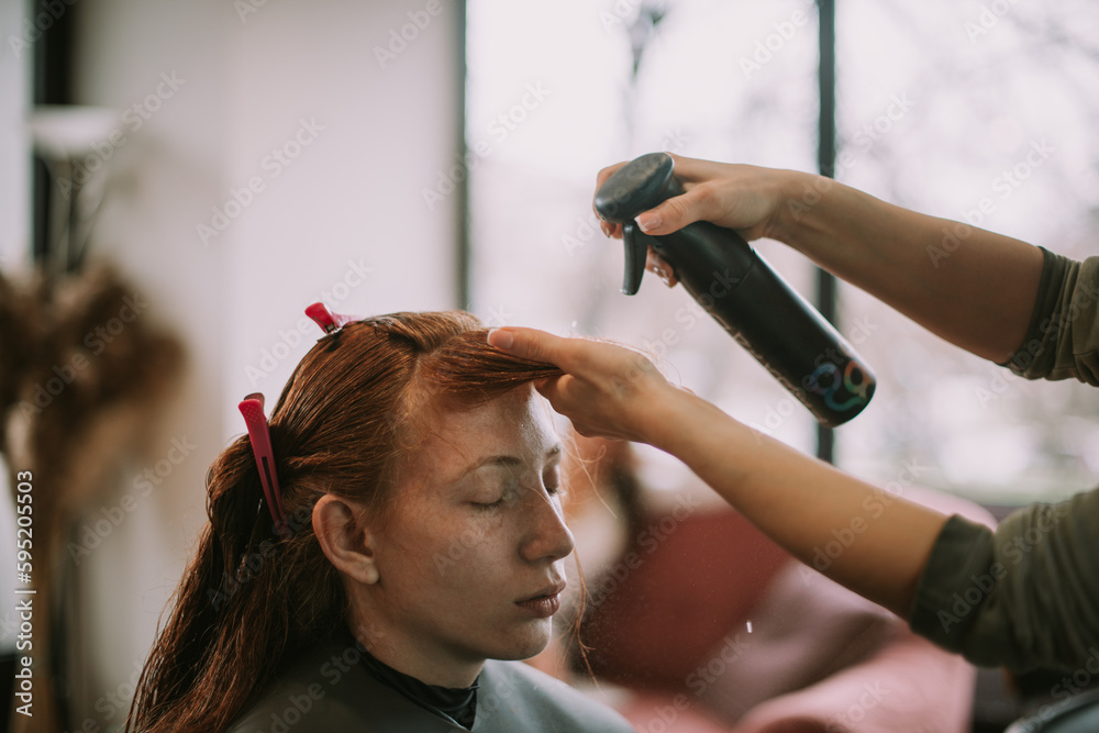 Naklejka premium Close up of putting hairspray at the salon