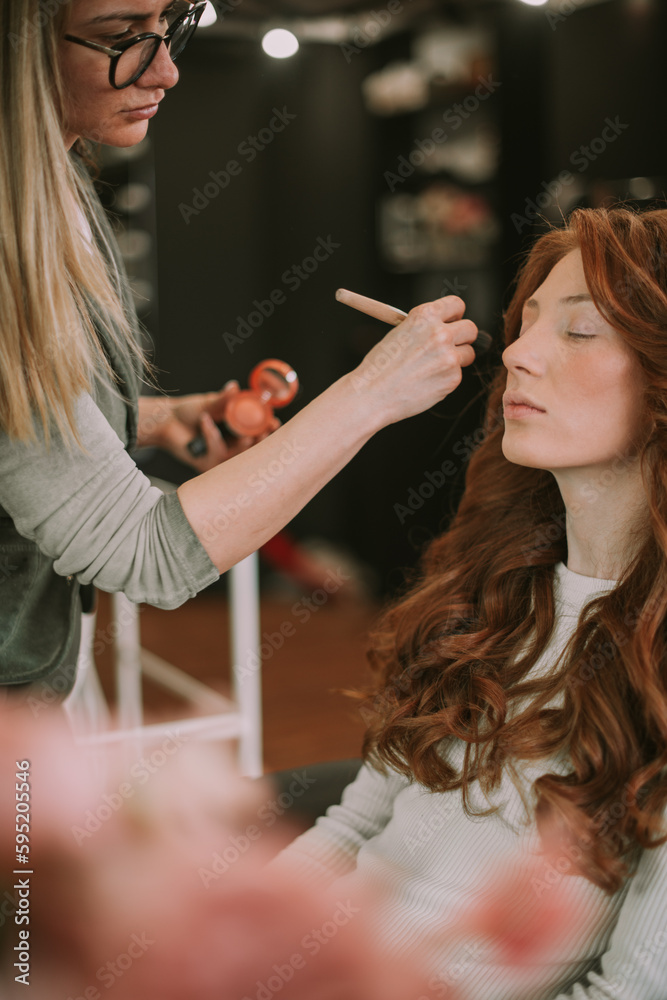 Fototapeta premium Close up of make up artist putting blush on her client