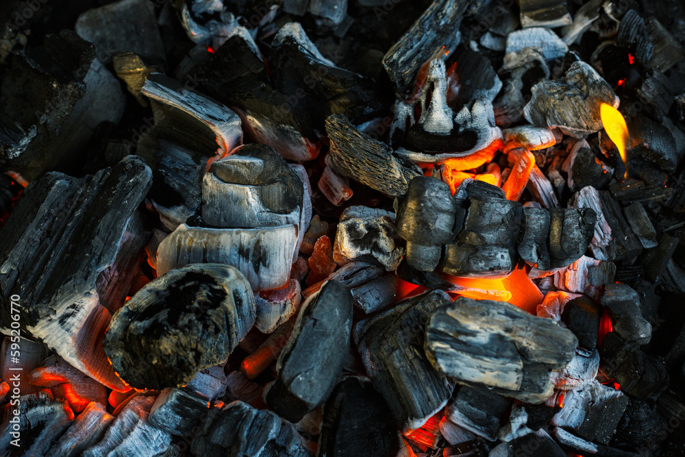 Burning charcoal for grilling close-up. Smoldering charcoal inside the grill gives heat for cooking pickled meat, barbecue, steak, vegetables, barbecue.