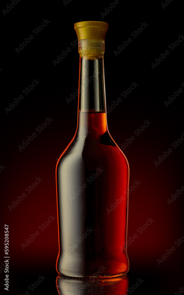 Bottle of unopened premium alcohol, brandy, or cognac on a black background. Ideal for a mock-up design.