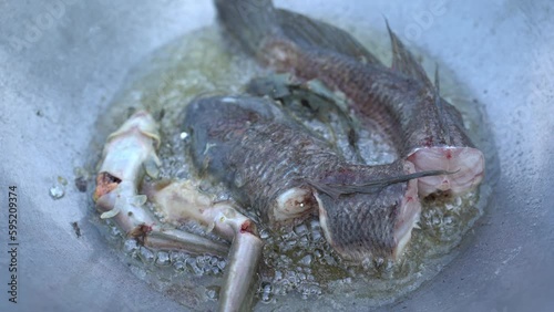 Frying fish in a pan of boiling oil.